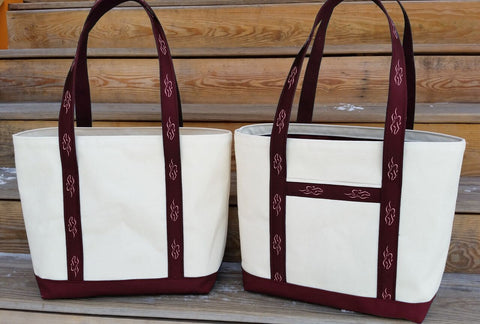 A heavy duty canvas tote bag with both front and internal pockets. Fully lined with cardinal liner to match the custom EMBRACE THE RACE ribbon sewn handles and solid cardinal canvas bottom.