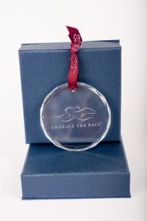 Beautiful circular glass ornament adorned with the EMBRACE THE RACE logo lightly etched.